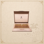 Arcadia Cigars Trinidad Robustos Extra cigars in a wooden travel humidor with gold branding on a beige background