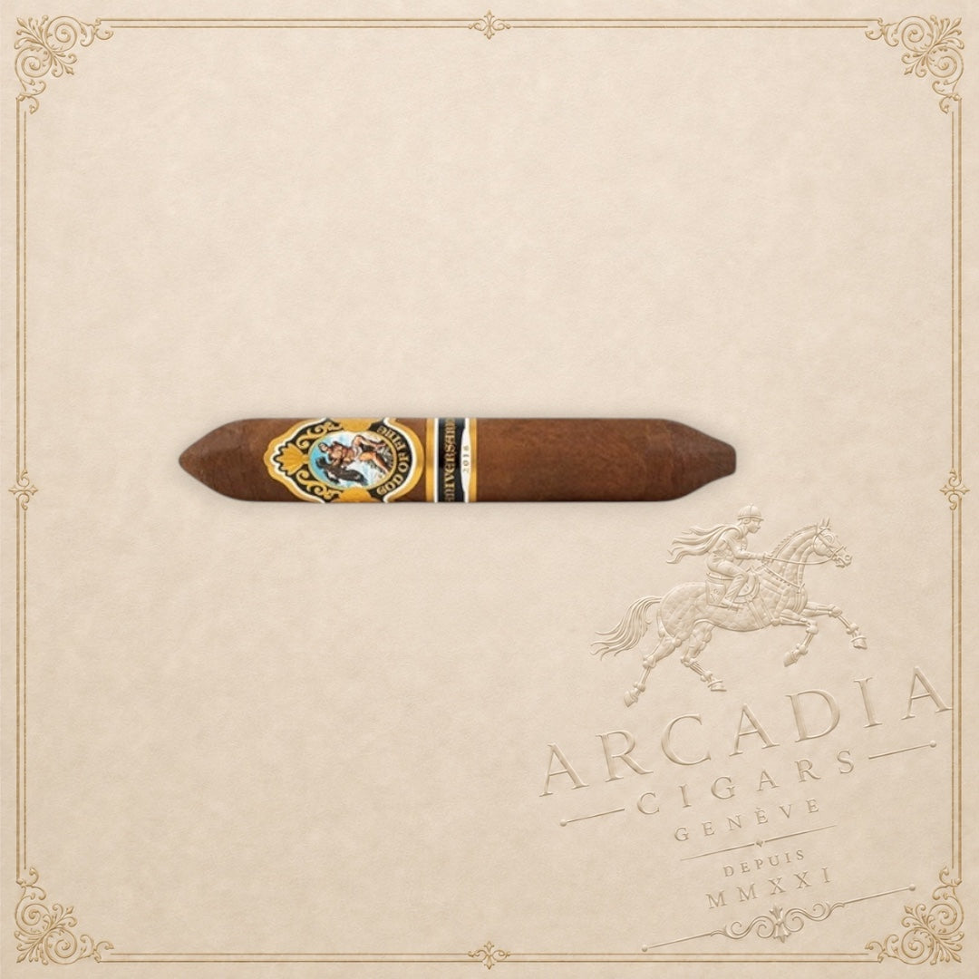 Arcadia Cigars God of Fire Serie Aniversario 60 cigar with ornate gold and black band on a textured cream background.