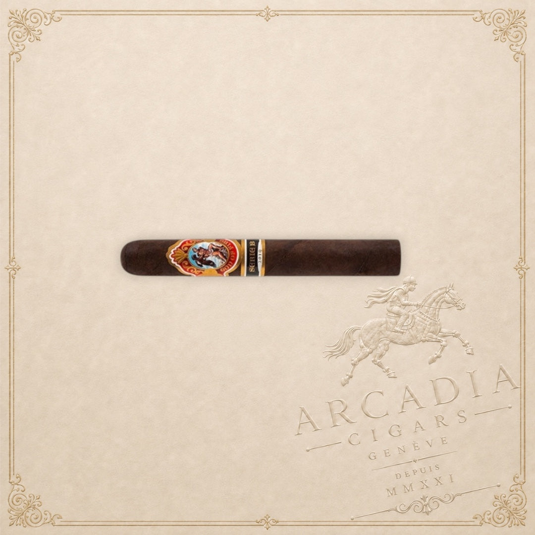 Arcadia Cigars God of Fire Serie B Gran Toro premium cigar with ornate band on a cream background
