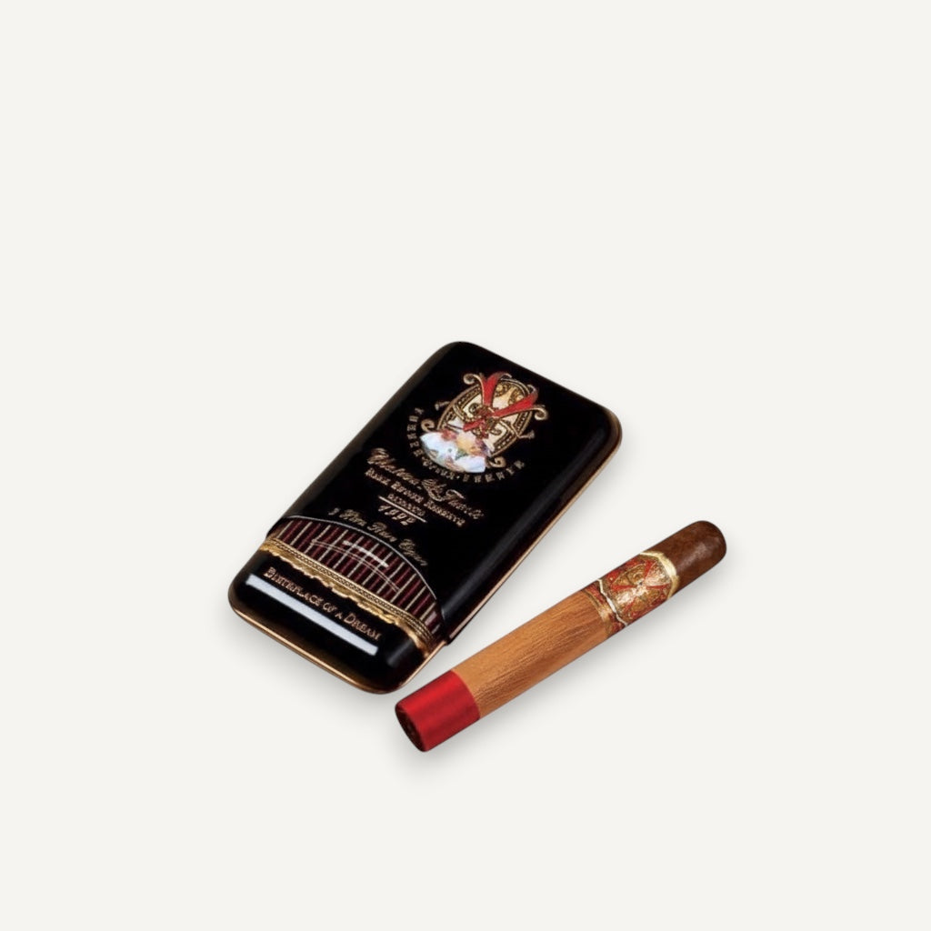 Arcadia Cigars Arturo Fuente Opus X Perfecxion X cigar with red band and gold accents, next to its black tin.