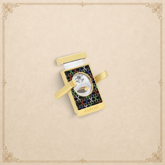 Arcadia Cigars S.T. Dupont gold cigar cutter with black face, red, white, green, blue X pattern, and textured grip.
