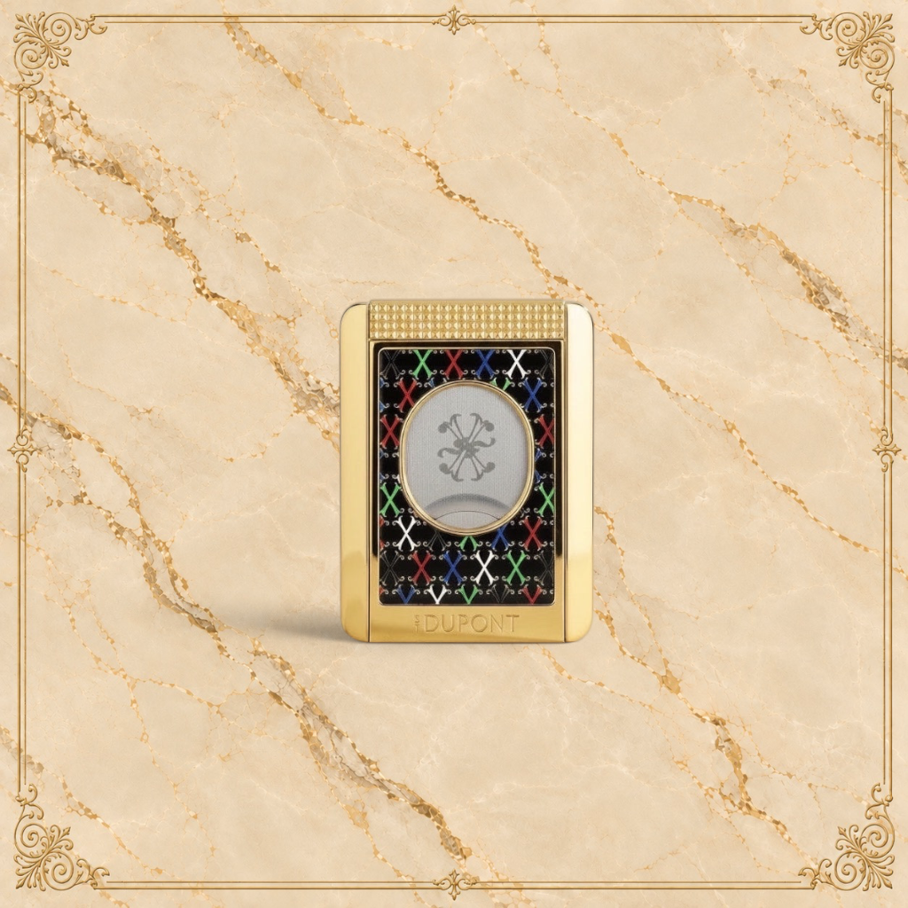 Arcadia Cigars S.T. Dupont gold cigar cutter with black face, red, white, green, blue X pattern, and textured grip.